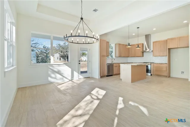 a kitchen with kitchen island granite countertop a sink and a stove top oven