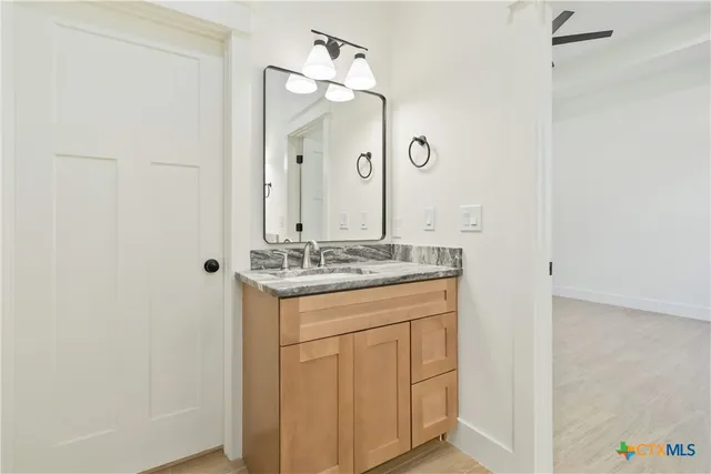 a bathroom with a granite countertop sink and a mirror