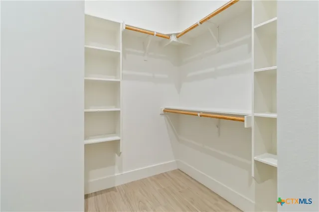 a view of walk in closet with empty racks