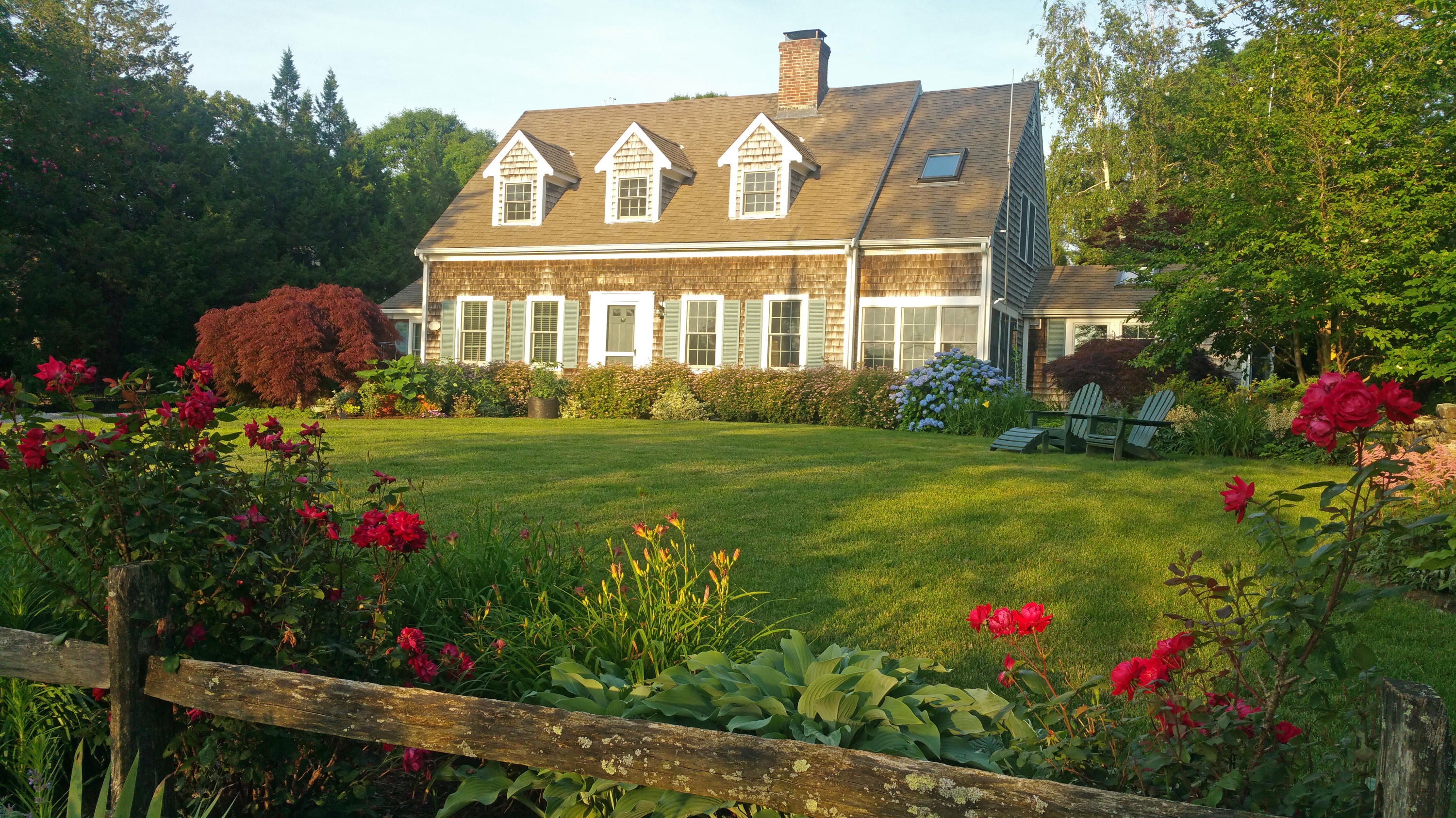 a front view of a house with a big yard and potted plants