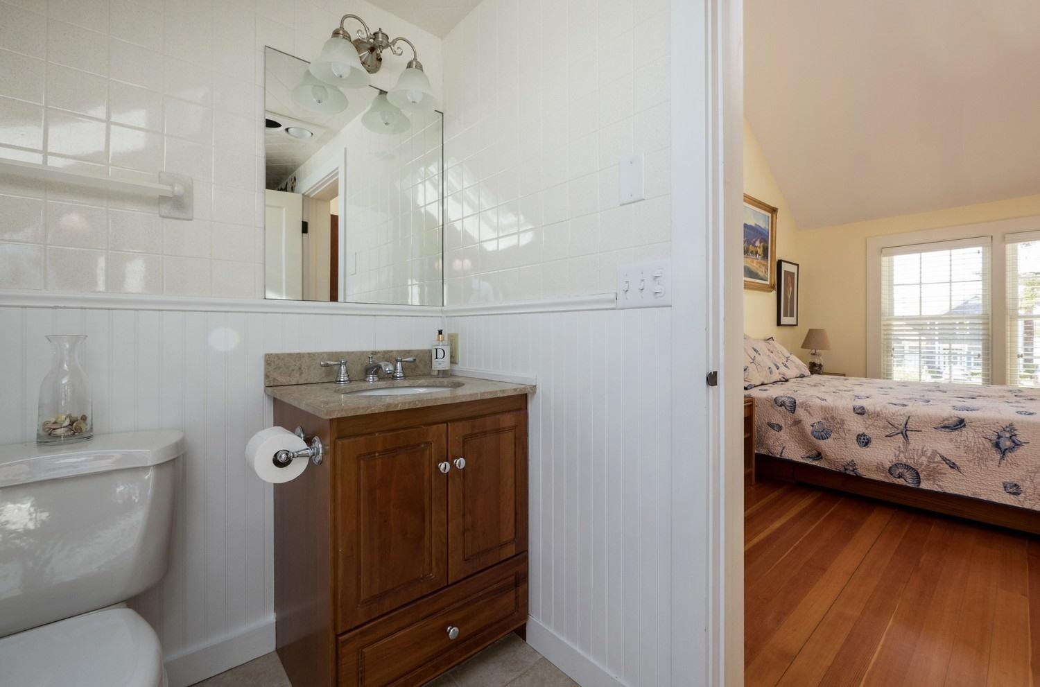 45 Gibson Road Orleans, MA 02653 - Photo 18 of 28 a bedroom with a bed and wooden floor