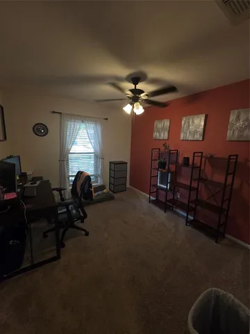 a view of a livingroom with furniture and a ceiling fan