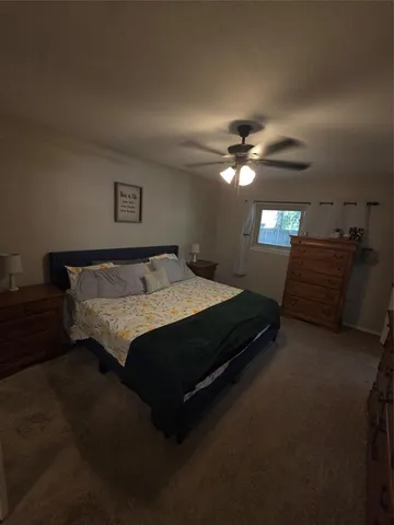 a spacious bedroom with a bed and a chandelier
