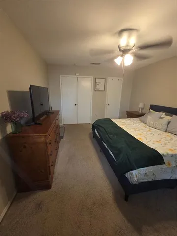 a bedroom with a bed and ceiling fan