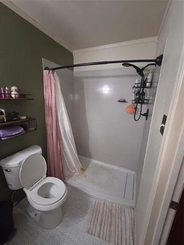 a white toilet sitting next to a shower curtain
