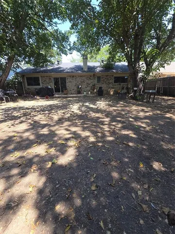 a backyard of a house with table and chairs