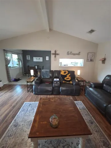 a living room with furniture and a wooden floor