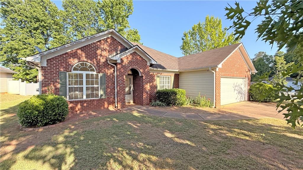 65 Lakeridge Court Covington, GA 30016 - Photo 2 of 17 a front view of a house with a yard and garage