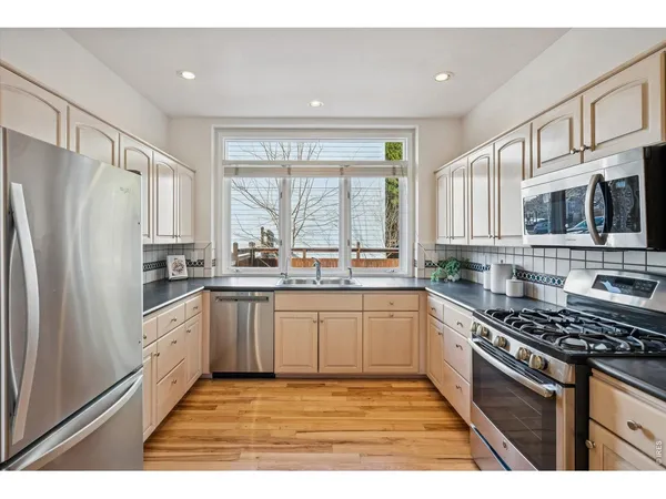 a kitchen with granite countertop white cabinets and stainless steel appliances