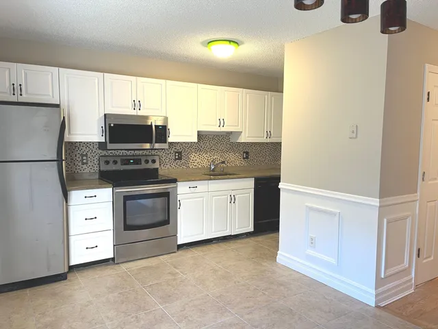 a kitchen with appliances a sink and cabinets