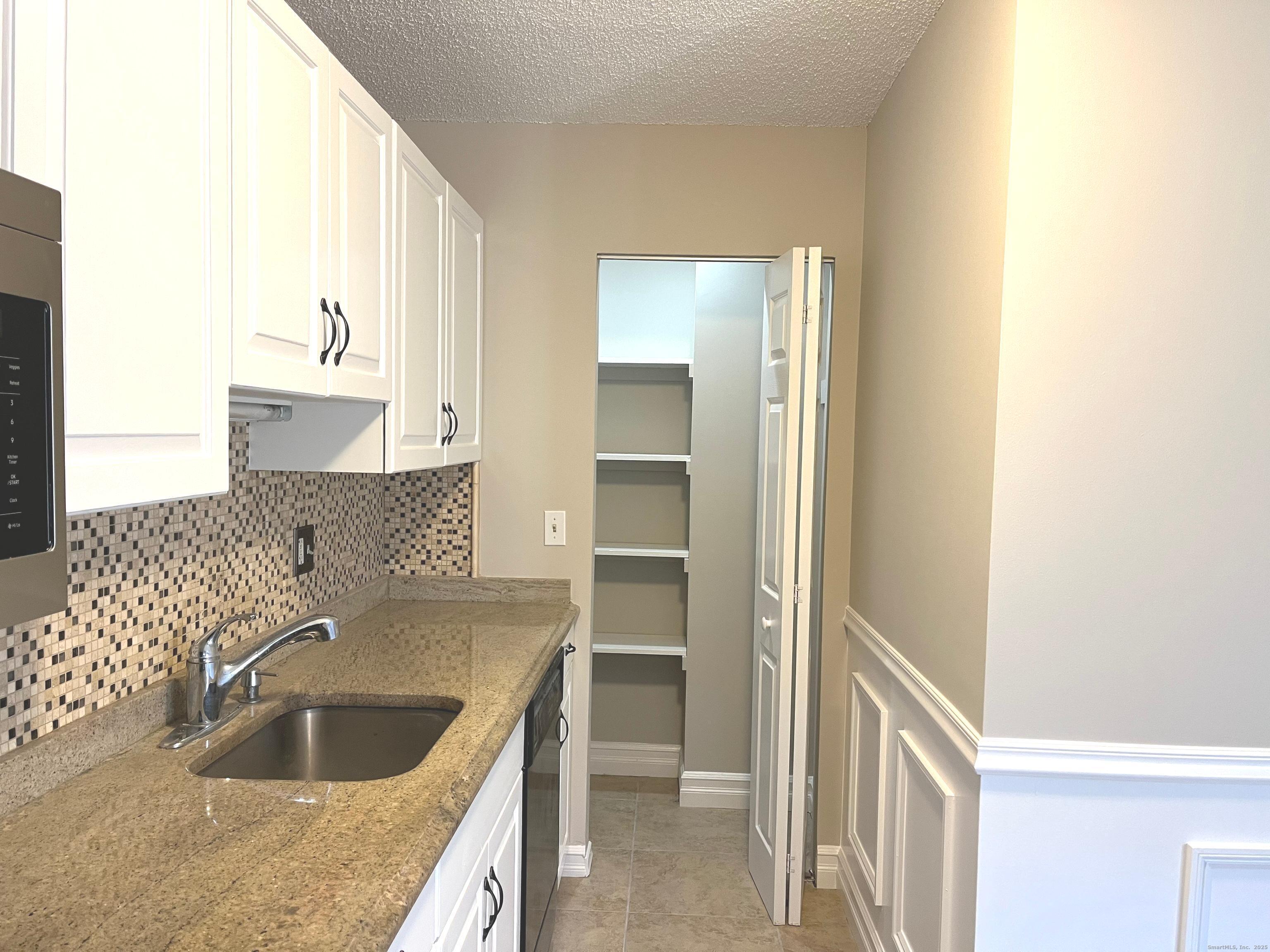 585 Park Road, Unit 112 Waterbury, CT 06708 - Photo 2 of 14 a kitchen with granite countertop a sink and a stove