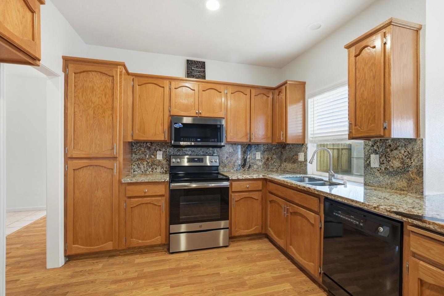 1672 Bailey Drive Ripon, CA 95366 - Photo 18 of 49 a kitchen with stainless steel appliances granite countertop a stove a sink dishwasher a refrigerator and a microwave