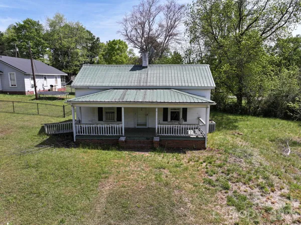 a view of a house with a yard and sitting area