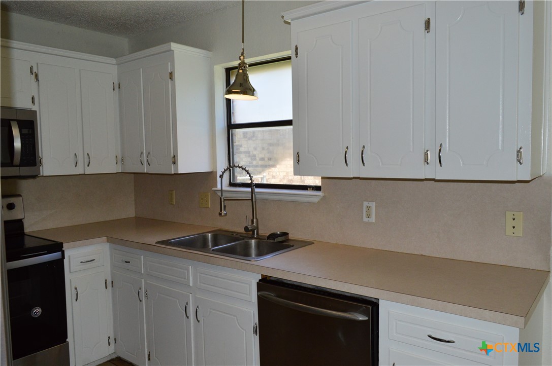1404 Rob Lane Copperas Cove, TX 76522 - Photo 13 of 31 a kitchen with stainless steel appliances white cabinets and a sink