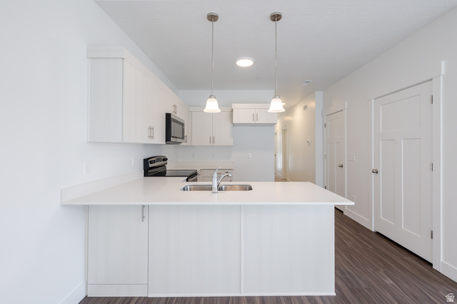 4662 Poplar Way, Unit Q302 Mapleton, UT 84664 - Photo 13 of 17 Kitchen featuring light countertops, hanging light fixtures, white cabinetry, a peninsula, and stainless steel appliances