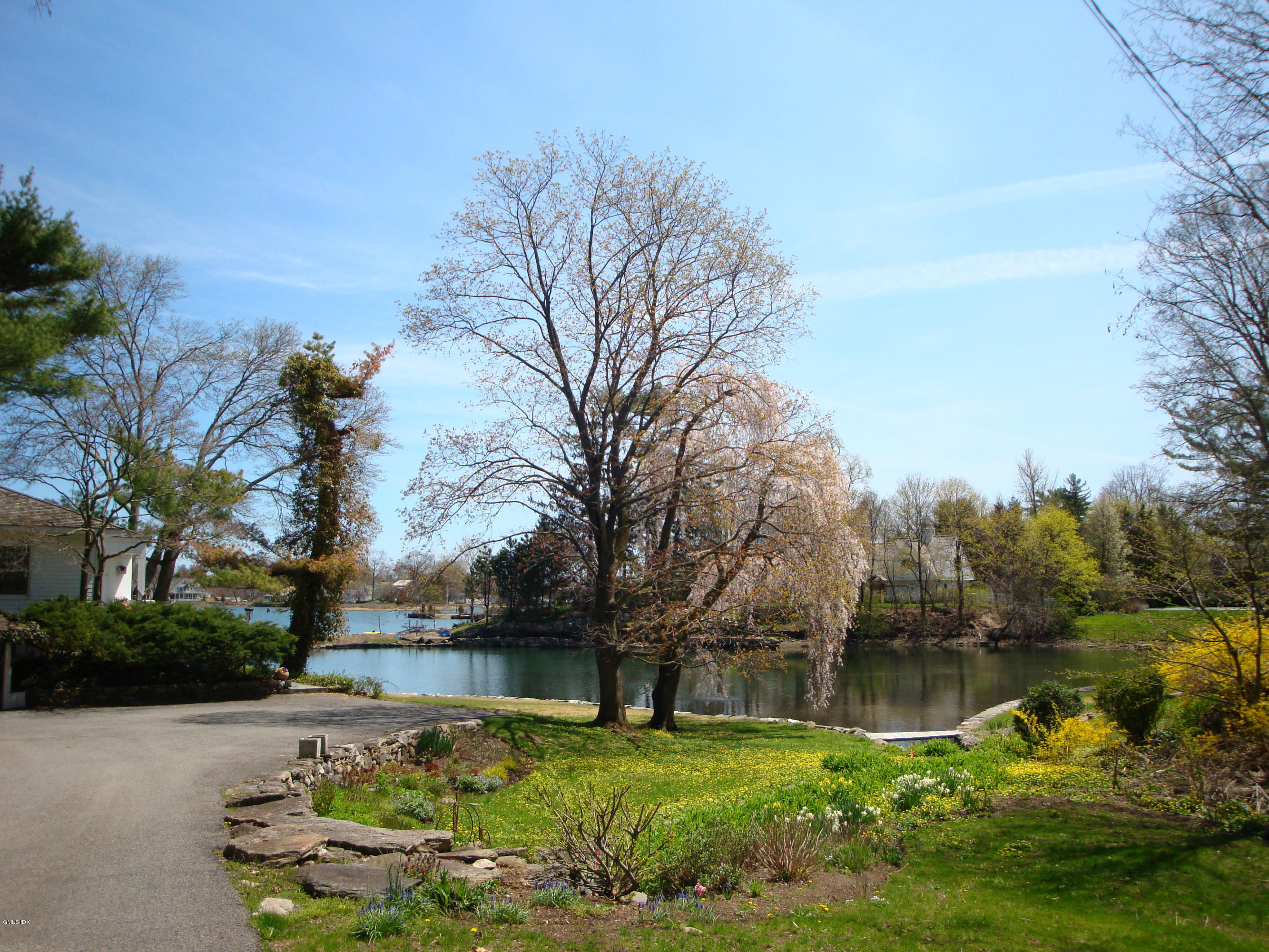 25 Willowmere Avenue Riverside, CT 06878 - Photo 2 of 24 a backyard of a house with lots of green space and lake view