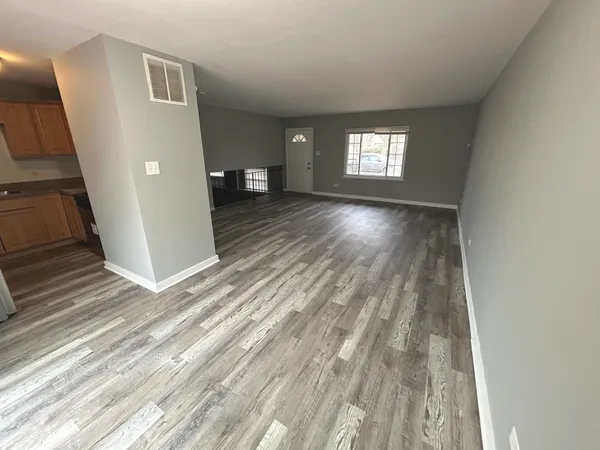 a view of a room with wooden floor and window