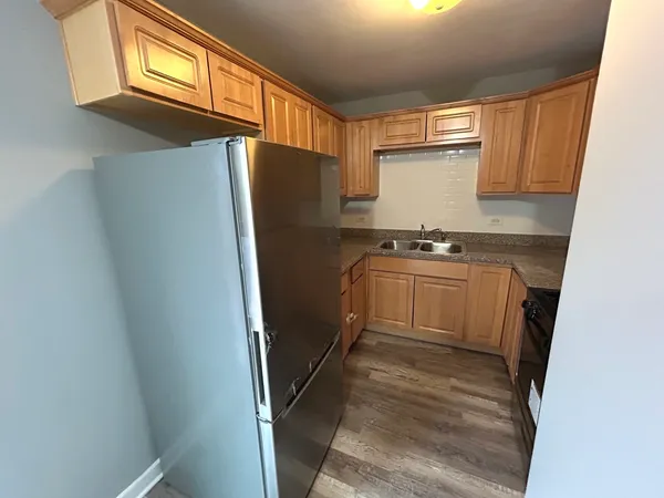 a kitchen with a refrigerator a stove a washer dryer and cabinets