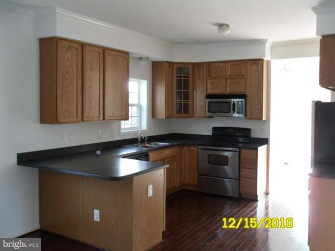 1311 Sulphur Spring Road Halethorpe, MD 21227 - Photo 16 of 16 a kitchen with granite countertop a sink a stove and cabinets