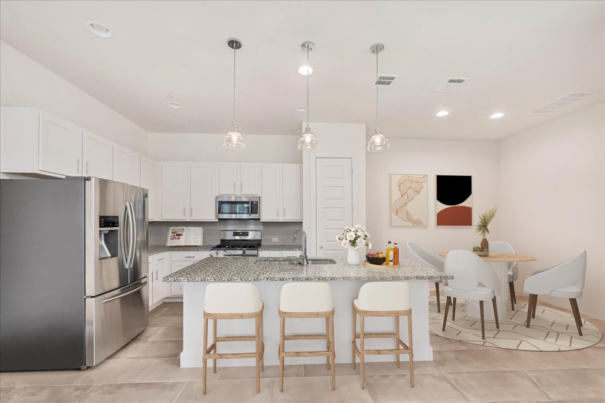 8922 Manchaca Road, Unit 906 Austin, TX 78748 - Photo 1 of 29 a kitchen with stainless steel appliances kitchen island granite countertop a table chairs refrigerator and microwave