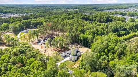 an aerial view of residential houses with outdoor space and trees
