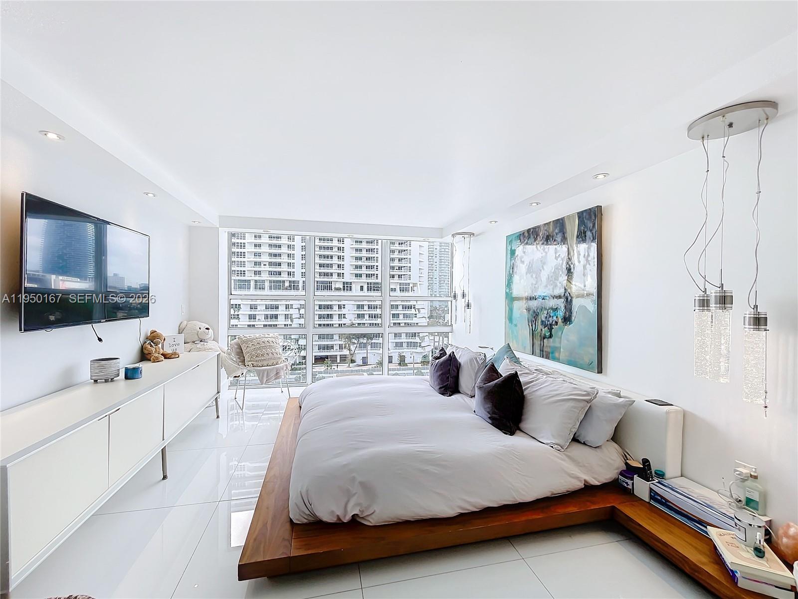 600 Northeast 36th Street, Unit 703 Miami, FL 33137 - Photo 32 of 48 a bedroom with a bed and a flat screen tv