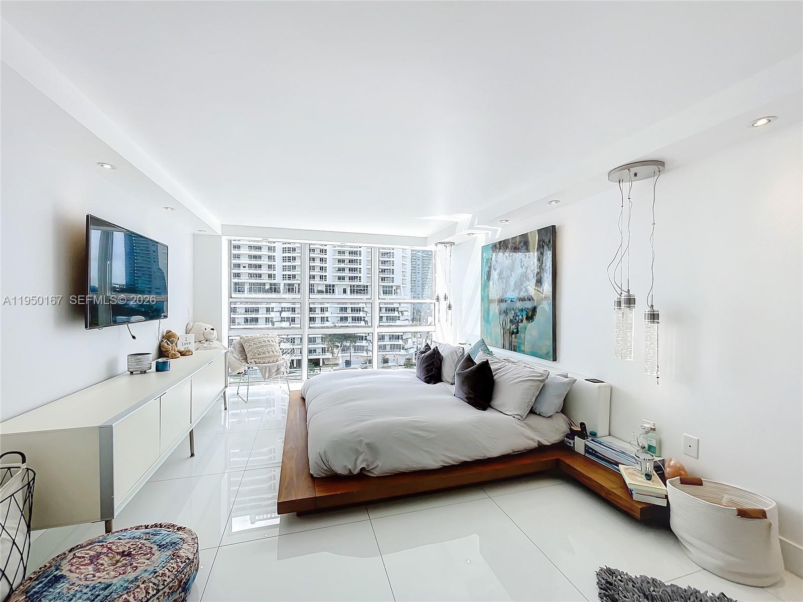 600 Northeast 36th Street, Unit 703 Miami, FL 33137 - Photo 33 of 48 a bedroom with a bed a flat screen tv and a window