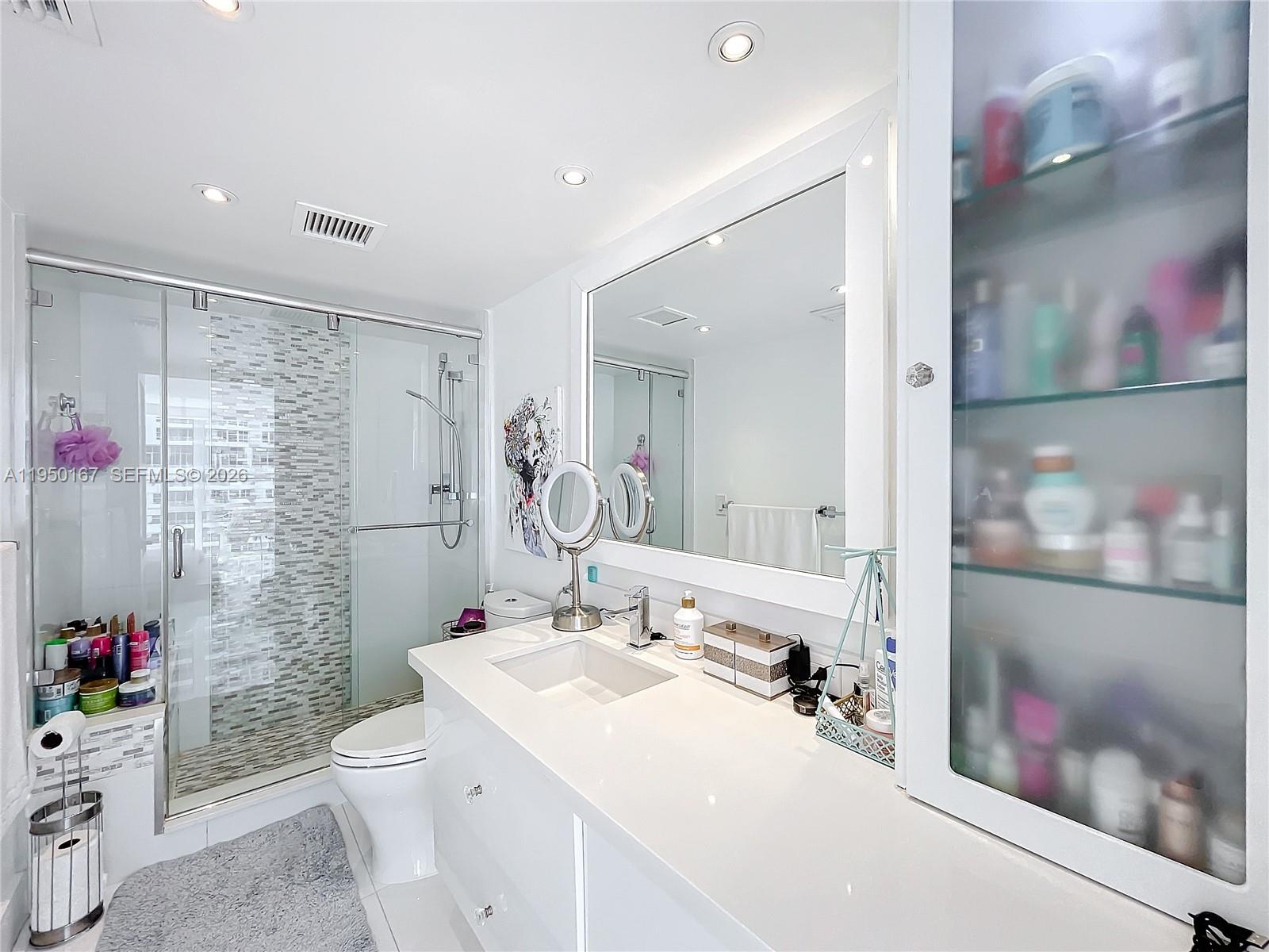 600 Northeast 36th Street, Unit 703 Miami, FL 33137 - Photo 35 of 48 a bathroom with a sink mirror and a toilet