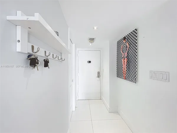 a kitchen with stainless steel appliances kitchen island granite countertop a sink a stove a refrigerator and white cabinets with wooden floor