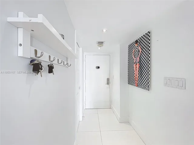 a kitchen with stainless steel appliances kitchen island granite countertop a sink a stove a refrigerator and white cabinets with wooden floor