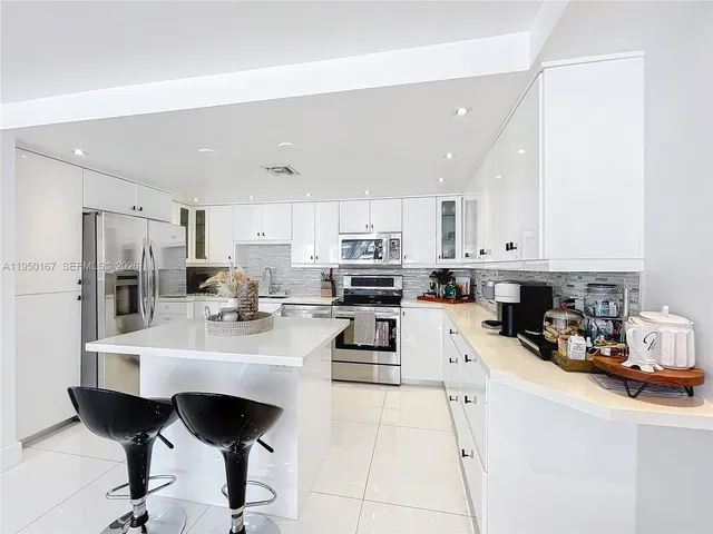 a kitchen with stainless steel appliances a stove a sink a refrigerator and cabinets