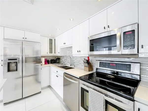 a kitchen with white cabinets stainless steel appliances and sink