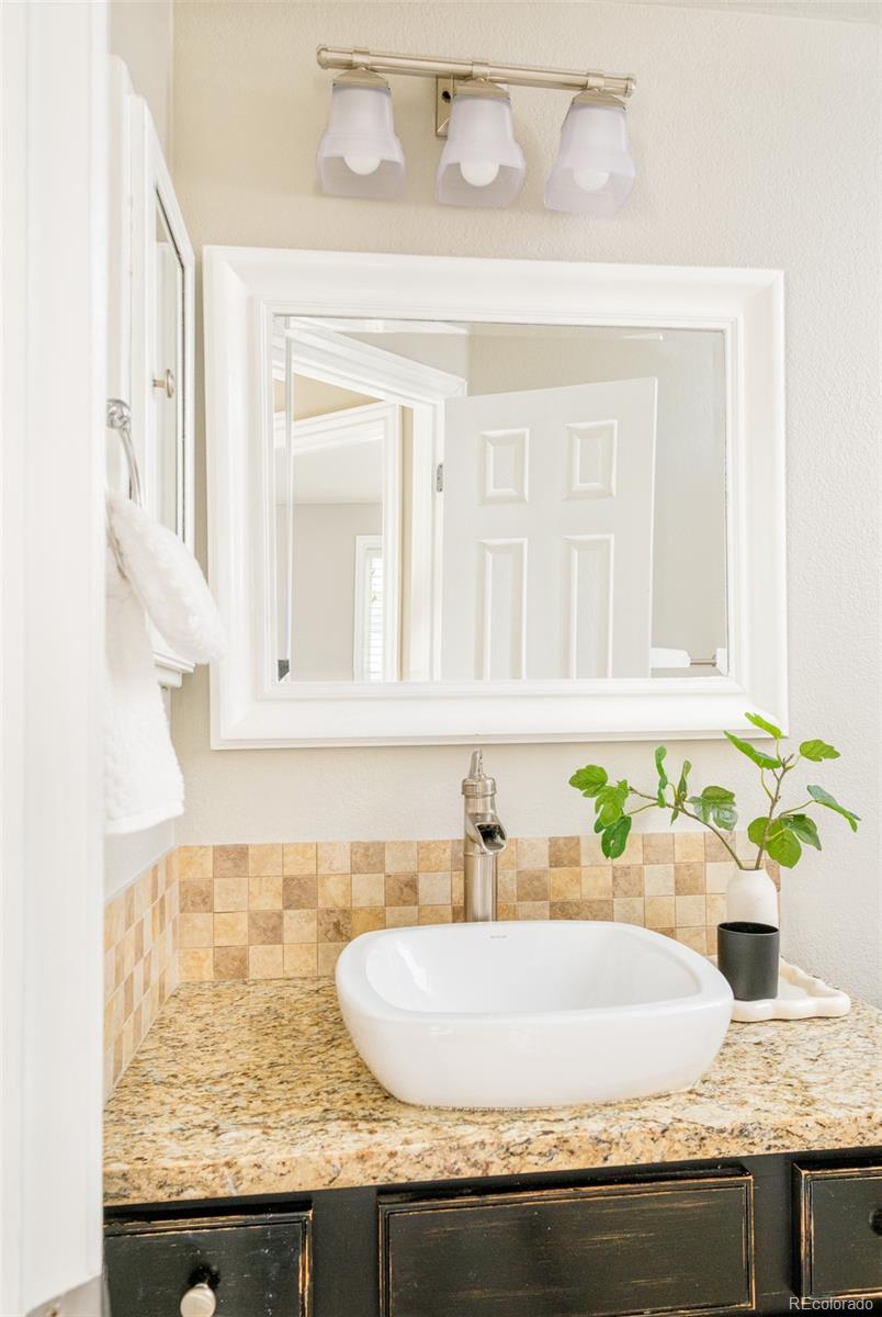2147 Pinon Circle Erie, CO 80516 - Photo 17 of 34 a bathroom with granite countertop a sink and a white wooden cabinets