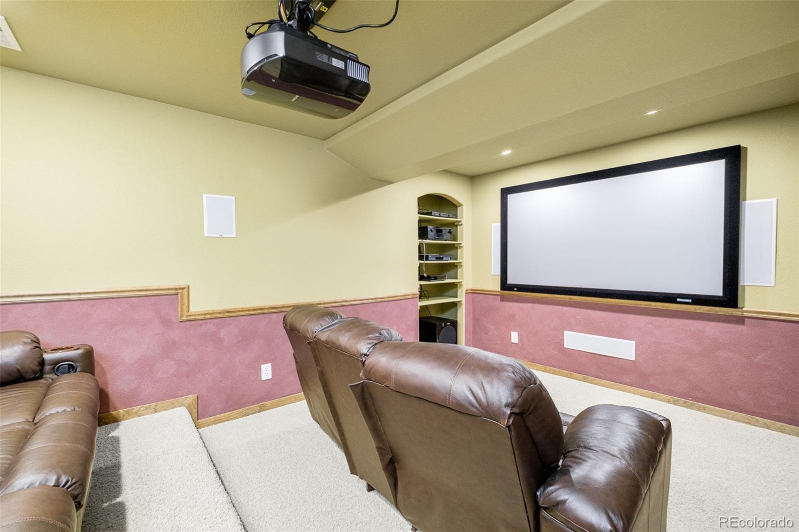 2147 Pinon Circle Erie, CO 80516 - Photo 26 of 34 a projector room with a projector and couches