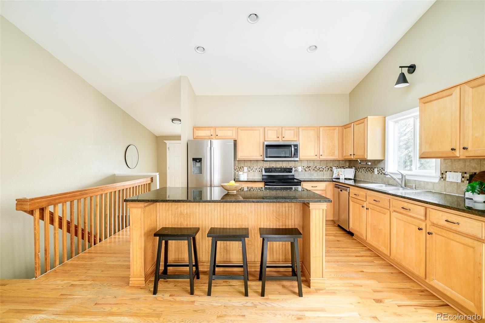 2147 Pinon Circle Erie, CO 80516 - Photo 4 of 34 a large kitchen with kitchen island a large window and wooden floor