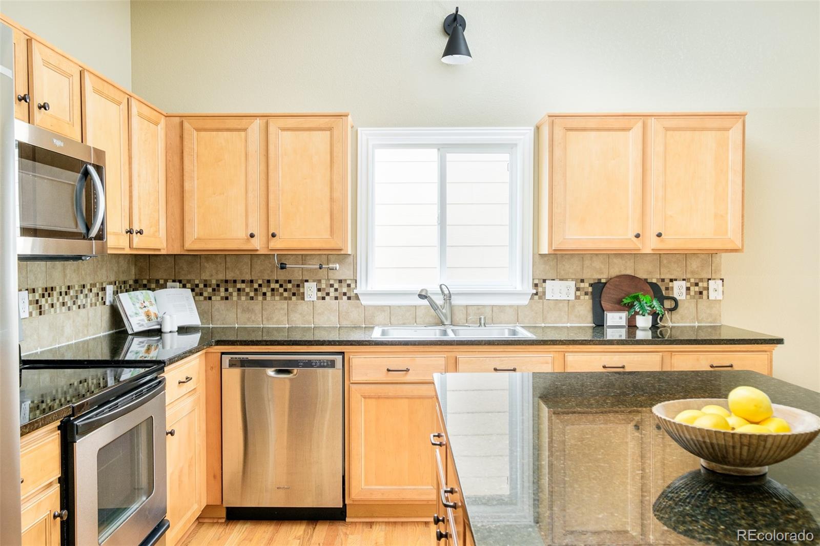 2147 Pinon Circle Erie, CO 80516 - Photo 5 of 34 a kitchen with stainless steel appliances granite countertop a sink a stove cabinets and a window
