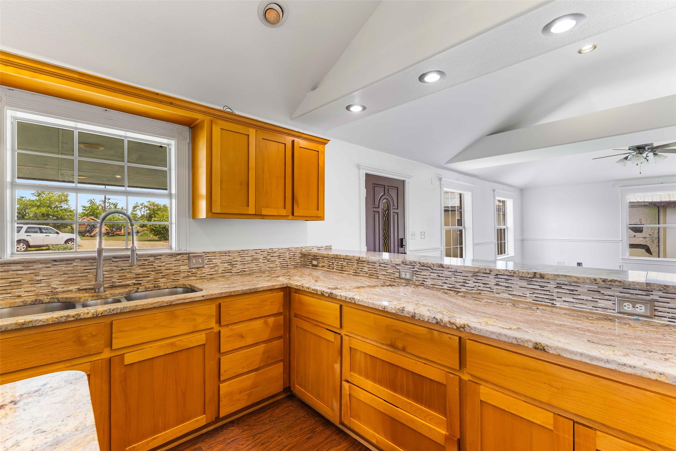 12212 Ballerstedt Road Elgin, TX 78621 - Photo 11 of 39 Kitchen featuring light stone countertops, recessed lighting, wood finish cabinetry, a ceiling fan, and plenty of natural light