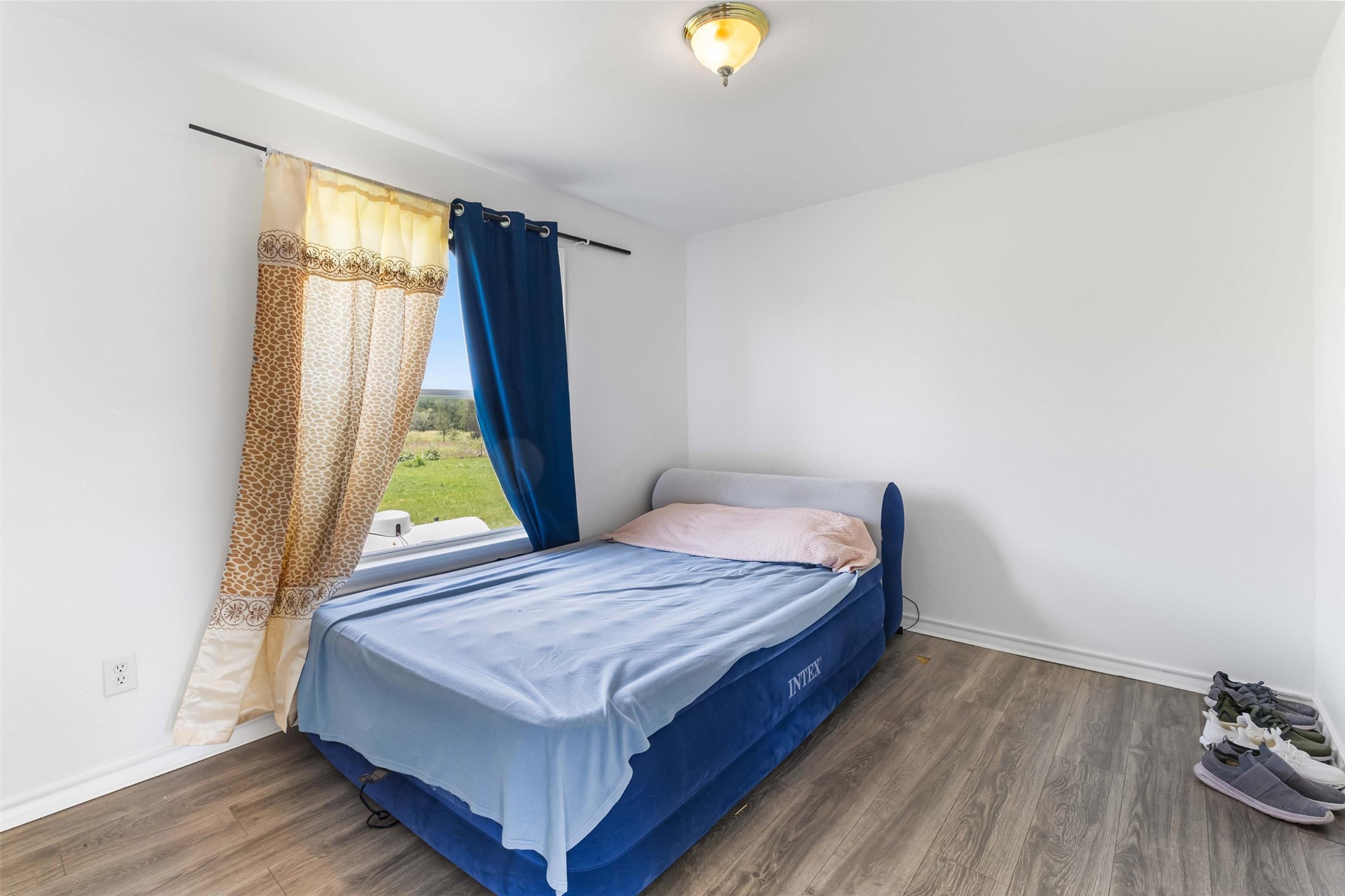 12212 Ballerstedt Road Elgin, TX 78621 - Photo 21 of 39 a bedroom with a bed and a window