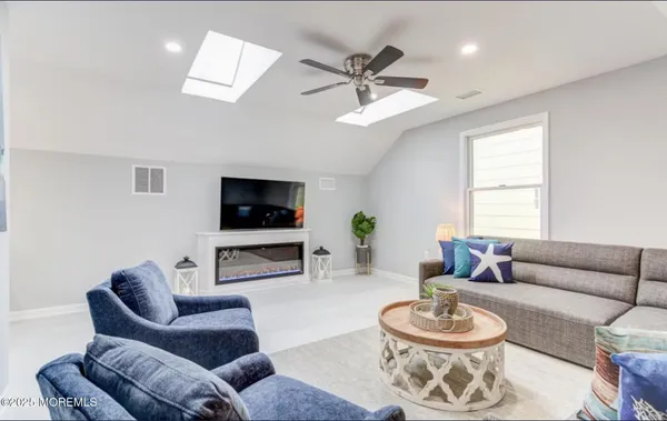 a living room with furniture a flat screen tv and a window