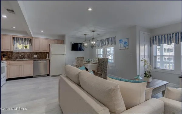 a living room with furniture and kitchen view