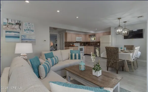 a living room with furniture and a dining table with kitchen view