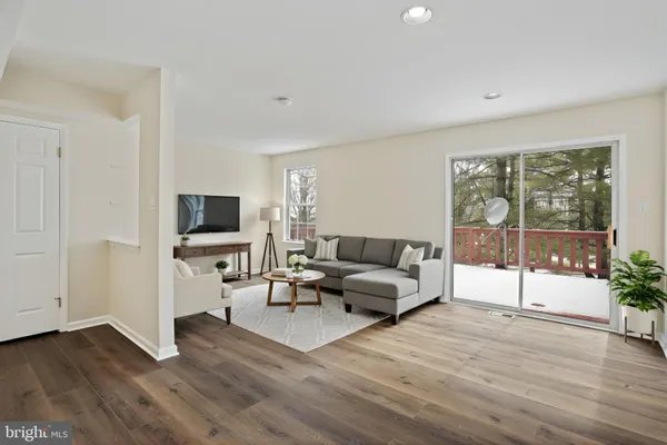 a living room with furniture a flat screen tv and a floor to ceiling window
