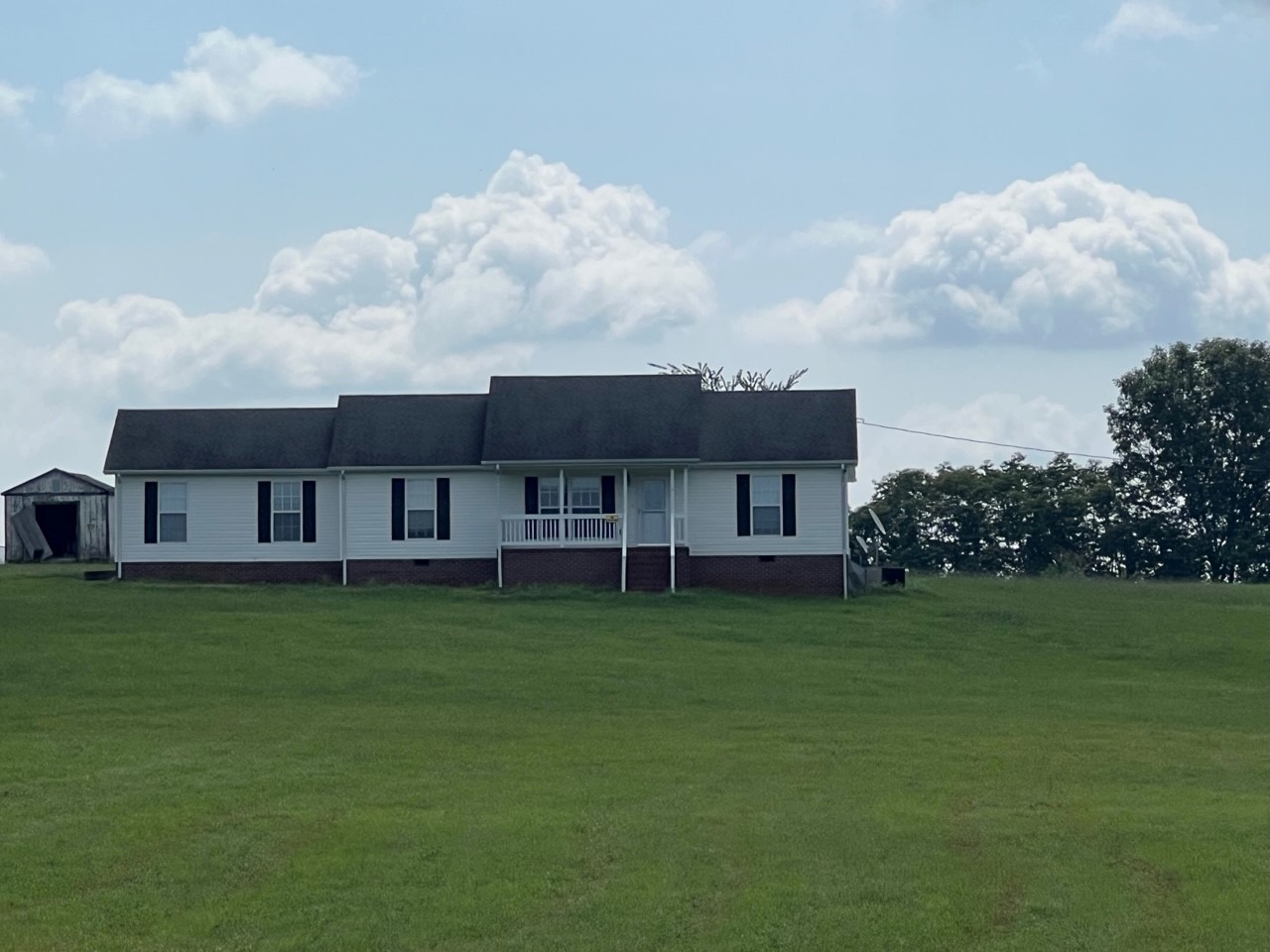 1058 Halls Mill Road Unionville, TN 37180 - Photo 23 of 32 a house that is sitting in the grass with large trees