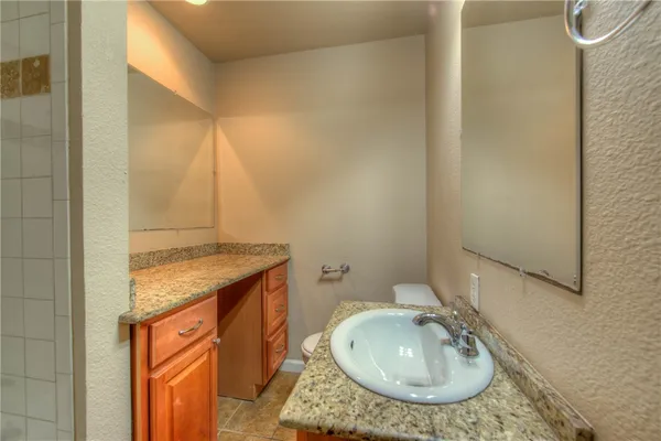 a bathroom with a granite countertop sink and a mirror