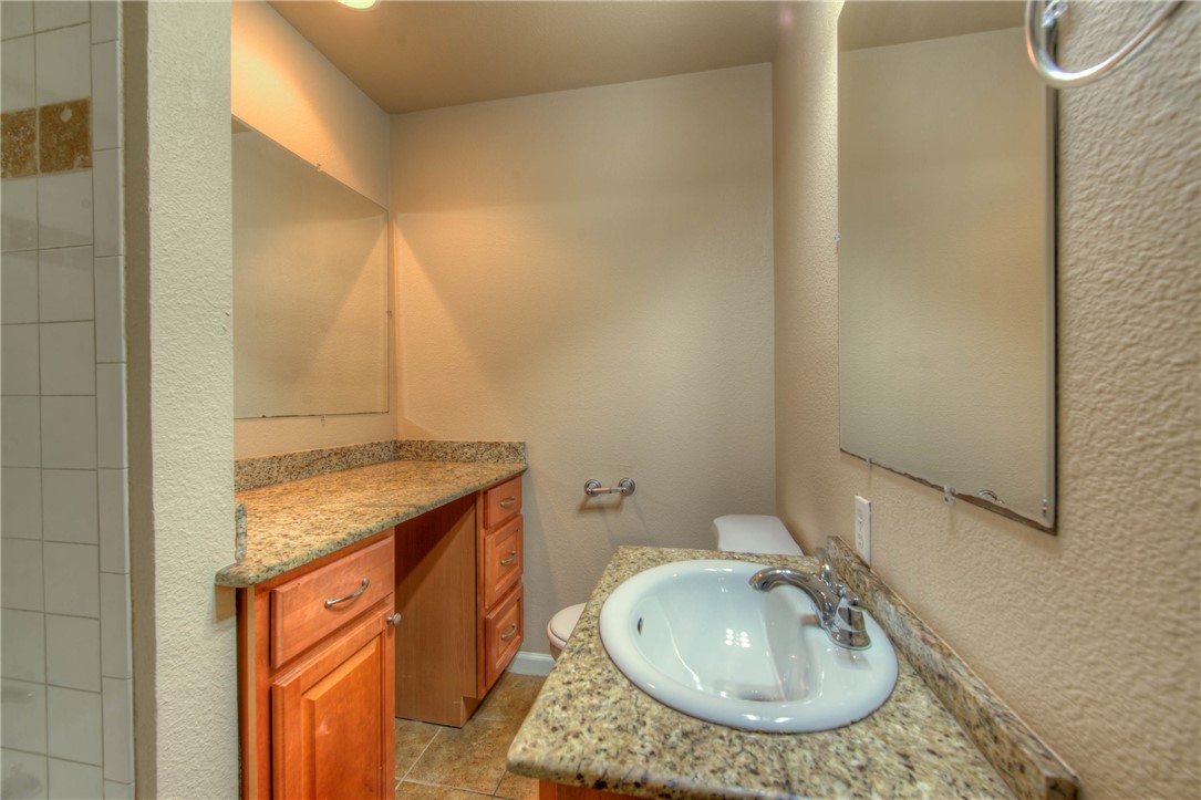 4805 Evans Avenue, Unit B Austin, TX 78751 - Photo 11 of 25 a bathroom with a granite countertop sink and a mirror