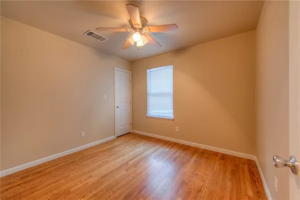 an empty room with a window and wooden floor