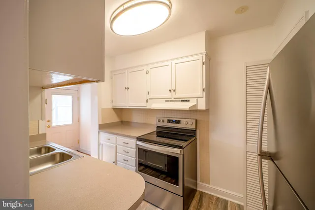a kitchen with stainless steel appliances a stove a sink and a refrigerator