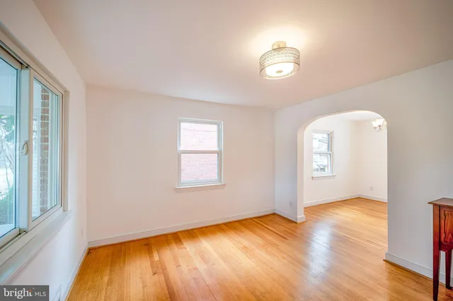 a view of empty room with window and wooden floor