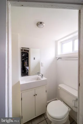 a bathroom with a toilet a sink a vanity and mirror