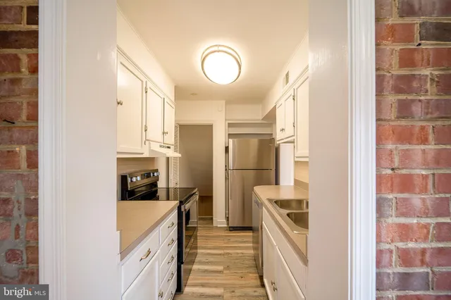 a kitchen with cabinets and a stainless steel refrigerator